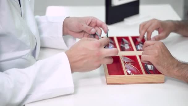 Orvos szemész segít az ügyfélnek kiválasztani a legmegfelelőbb szemüveget Szemészeti Klinika. — Stock videók