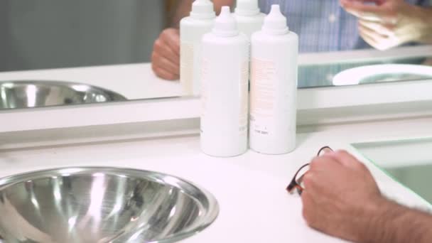 Man putting on contact lens in ophthalmology clinic. — Stock Video