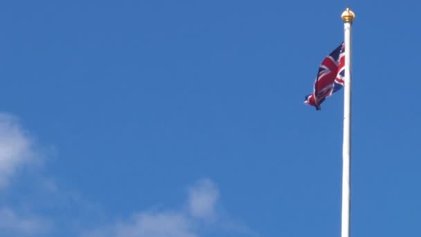 Bandera británica con espacio de copia en el viento y el cielo azul. En un buen día soleado . — Vídeo de stock