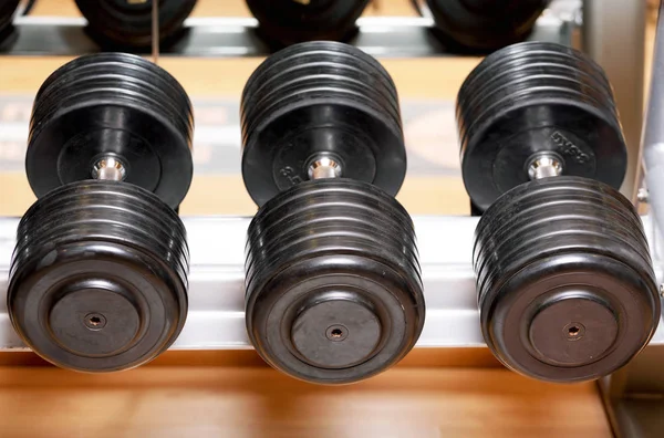 Différentes tailles et poids de haltères poids libres dans une salle de gym . — Photo