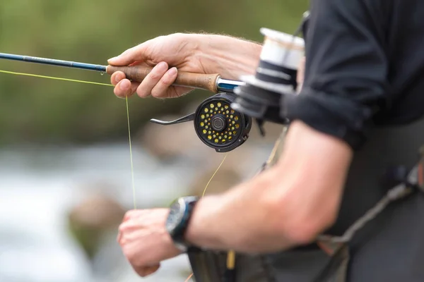 Manusia terbang memancing dengan gulungan dan tongkat. Sport fly fisher man close up on reel . — Stok Foto