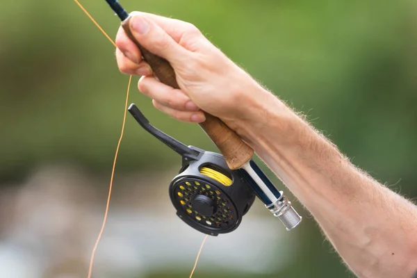 Fliegenfischen mit Spule und Rute. Sport Fliegenfischer Mann aus nächster Nähe auf Spule. — Stockfoto