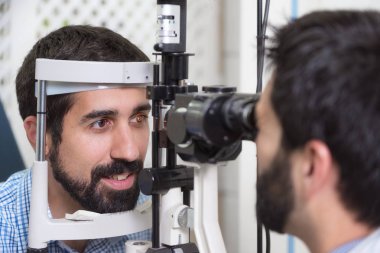 erkek doktor oftalmolog modern klinikte yakışıklı genç adamın göz görme kontrol ediyor. Oftalmoloji kliniğinde doktor ve hasta.