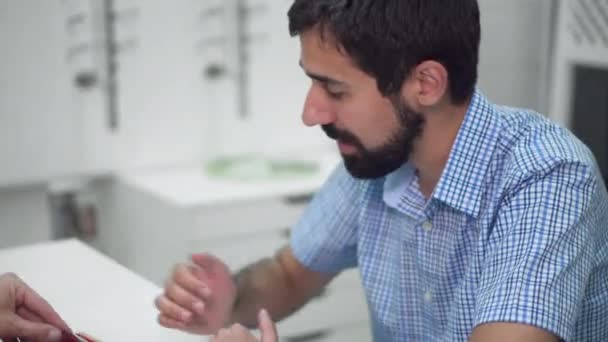 Oftalmólogo médico está ayudando a un cliente a elegir las gafas más adecuadas en la clínica oftalmológica . — Vídeos de Stock