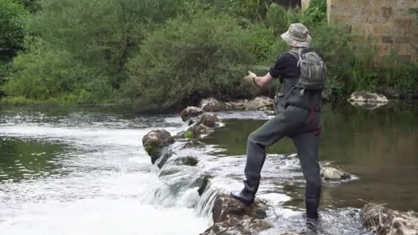 Fischer angelt auf dem Fluss und hält die Angel in der Hand. — Stockvideo