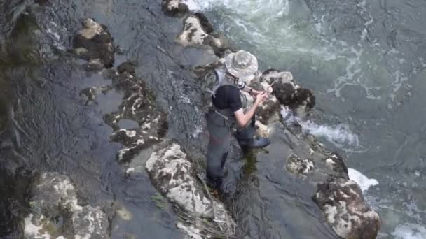 Slow motion aerial view of fisherman fishing in a river with a fishing rod. — Stock Video