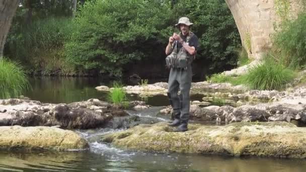 Hombre pescando en el río. pescador en el agua. pescador mostrar el uso de la técnica de pesca. ¡Rod! pasatiempo y actividad deportiva . — Vídeo de stock