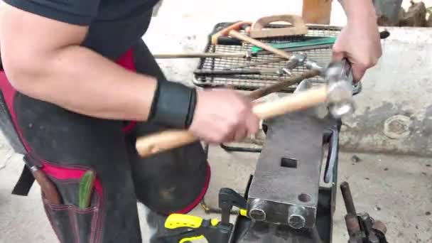 Farrier blacksmith making horse shoe with hammer and anvil. — Stock Video