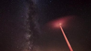 Arka planda samanyolu ile temiz enerji üreten rüzgar türbinlerinin gece zamanı atlamalı. 