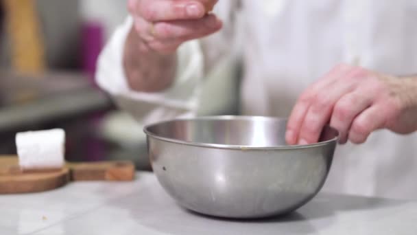 Chef rompiendo un huevo en un tazón . — Vídeos de Stock