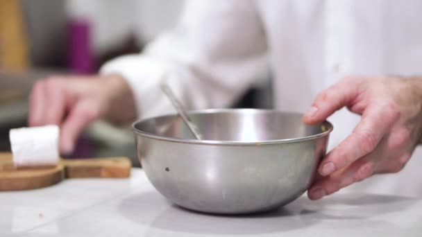 Koch gießt Salz in eine Schüssel. — Stockvideo