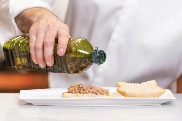 Chef vertiendo aceite de oliva sobre deliciosa comida . — Foto de Stock