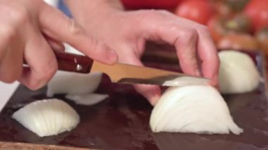 Soğan Doğrama, Yakın Çekim. Yavaş çekim. Kadın elleri ahşap bir tahta üzerinde mutfakta soğan kesti.