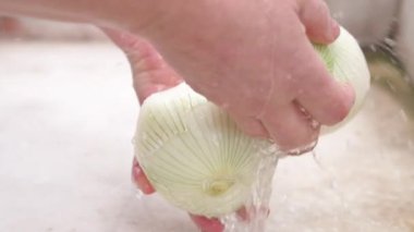 Kadın elleri mutfak lavaboda beyaz soğan yıkama, yavaş hareket kapatın.