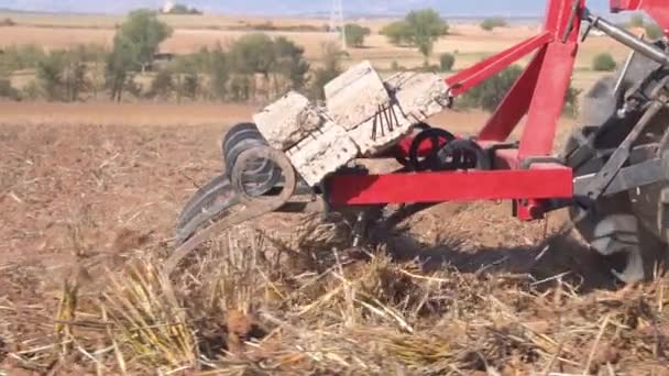 Tractor rojo con suelo de campo de soplado de arado Cerrar Vista en cámara lenta . — Vídeo de stock