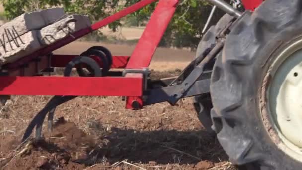 Tractor rojo con suelo de campo de soplado de arado Cerrar Vista en cámara lenta . — Vídeo de stock