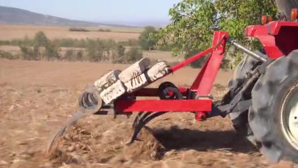 Landbouwmachines. Close-up van trekker met ploegzaai- en teeltveld. — Stockvideo