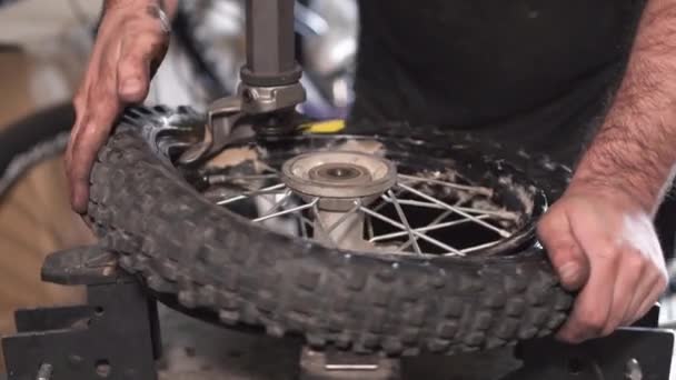 Mecánica reparación de neumáticos de motocicleta dañados, en taller de reparación . — Vídeo de stock