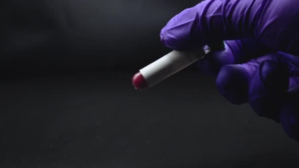 Тщательный анализ крови в перчатках на черном фоне. — стоковое видео