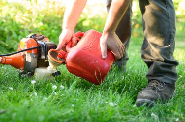 Bahçıvan, çalı kesiciyi kapat. Bahçıvanlık malzemeleri bakımı. Çim biçme makası ile çimen bakımı.