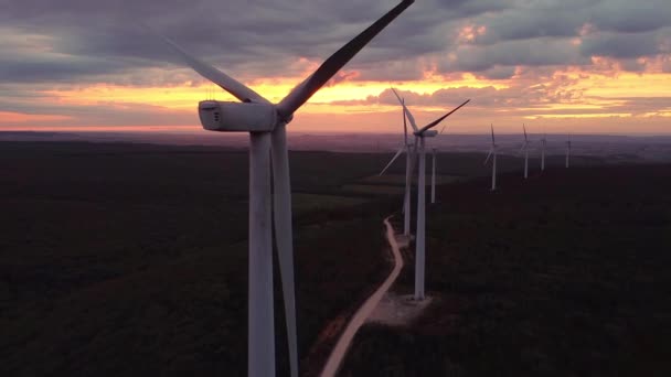 Close up Parque de turbinas eólicas en hermoso paisaje púrpura noche de montaña. Producción de energía renovable para el mundo ecológico verde. Vista aérea del parque de granjas de molinos de viento en la montaña de la noche . — Vídeos de Stock