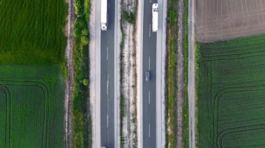  Kırsal alanda trafiği olan bir otoyol. Arabaları ve kamyonları olan banliyö otoyolu. Seyahat ve ulaşım. Hava görünümü