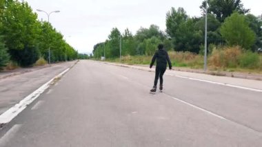 Çekimi takip edin, yolda paten yapan genç bir kadının dikiz görüntüsü..