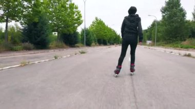 Çekimi takip edin, yolda paten yapan genç bir kadının dikiz görüntüsü..