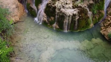 Ortaçağ köyü Orbaneja del Castillo 'da cennet gibi bir şelalenin sinematik görüntüsü. Burgos, İspanya 'nın ünlü turistik beldesi.