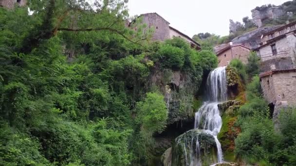 Fotografia aérea cinematográfica de uma cachoeira idílica numa aldeia medieval, Orbaneja del castillo. Destino turístico famoso em Burgos, Espanha . — Vídeo de Stock