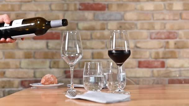 Camarero vertiendo una botella de vino tinto en elegante restaurante. — Vídeos de Stock