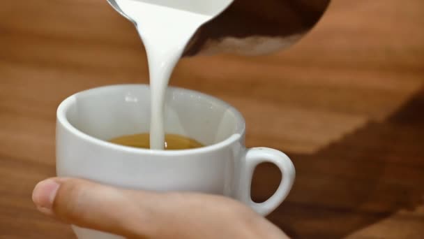 ภาพระยะใกล้ของบาริสต้าแสดงให้เห็นถึงศิลปะของการเทและเตรียมถ้วยกาแฟ การทําศิลปะลาเต้ . — วีดีโอสต็อก