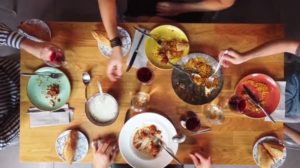 Top view, people raising glasses over festive dinner table during celebration with friends and family. — Stock Video