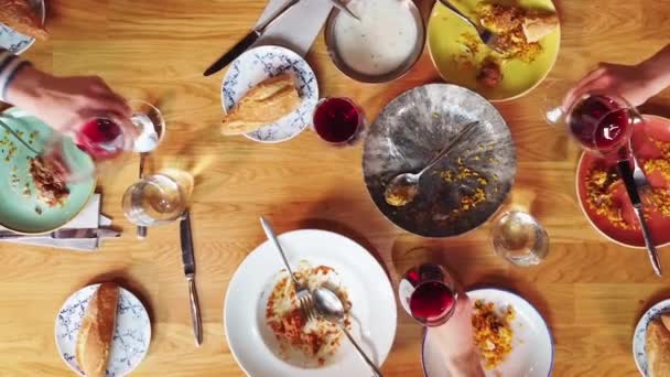 Top view, people raising glasses over festive dinner table during celebration with friends and family. — Stock Video