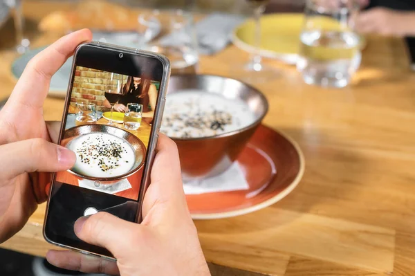 Mano de hombre con smartphone fotografiando comida en restaurante o cafetería — Foto de Stock