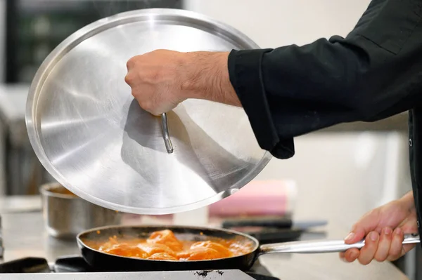 Close up, chef covering frying pan with lid at restaurant kitchen — Stock Photo, Image