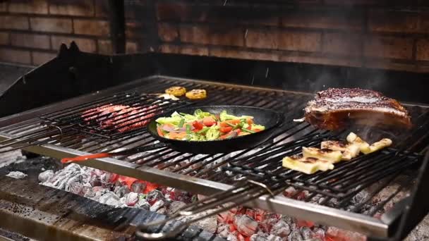 Vue rapprochée, de la main du chef masculin, cuisson des aliments sur le barbecue au charbon de bois dans la cuisine commerciale. — Video