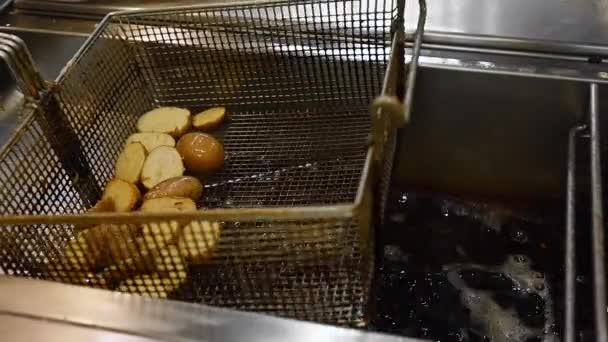 Preparing potatoes in deep fryer with boiling oil. — Stock Video