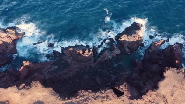 Drón repül a sziklás parton. Gyönyörű tengerpart hullámokkal. Légi kilátás a nagy tengeri sziklák. Top view a nagy hullámok sújtotta tengerparton Tenerife, Kanári-szigetek, Spanyolország. — Stock videók