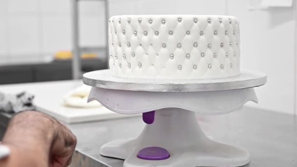 Кондитер прикрашає весільний торт білою помадкою  . — стокове відео