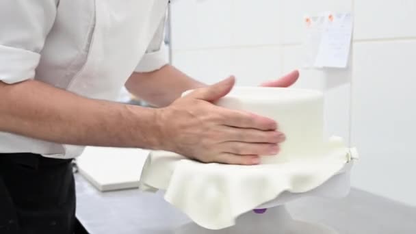 Confectioner dekorera en bröllopstårta med vit fondant . — Stockvideo