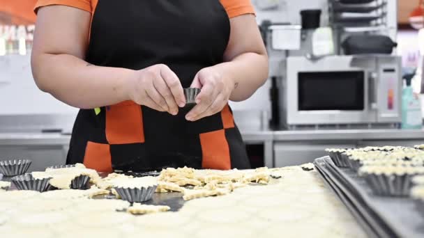Pekařský kuchař pečení koláčky, uvedení těsta v pečení nádobí, v kuchyni cukrárny. — Stock video
