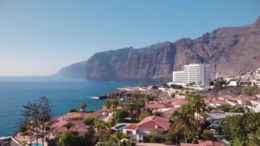Arka planda devlerin uçurumlarının olduğu Puerto de Santiago köyünün havadan görünüşü, Tenerife, Kanarya adaları, İspanya.