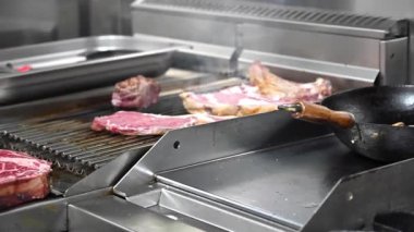 Ticari mutfakta et pişiren tanınmayan bir şefin yakın görüntüsü..