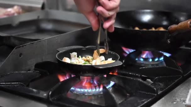 Close-up uitzicht op een onherkenbare chef-kok koken garnalen in commerciële keuken. — Stockvideo