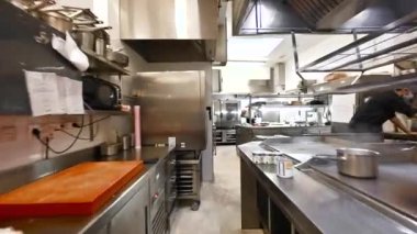 Profesyonel şeflerden oluşan bir ekip ticari bir mutfakta yemek hazırlıyor ve pişiriyor. POV çekimi