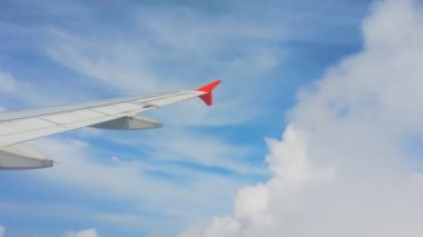Uçakların kanatları ve gökyüzü manzarası bulutların üzerindeki pencereden
