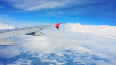 Uçakların kanatları ve gökyüzü manzarası bulutların üzerindeki pencereden