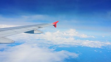 Uçakların kanatları ve gökyüzü manzarası bulutların üzerindeki pencereden