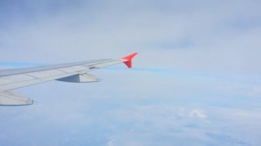 Uçakların kanatları ve gökyüzü manzarası bulutların üzerindeki pencereden